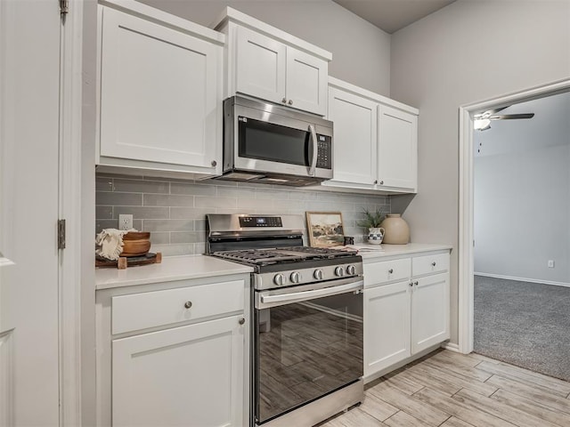 kitchen with tasteful backsplash, white cabinetry, appliances with stainless steel finishes, and ceiling fan