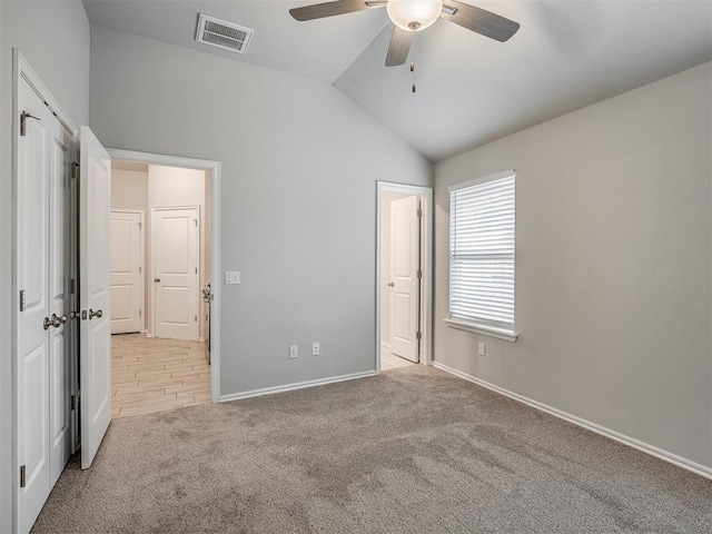 unfurnished bedroom featuring light carpet, vaulted ceiling, and ceiling fan