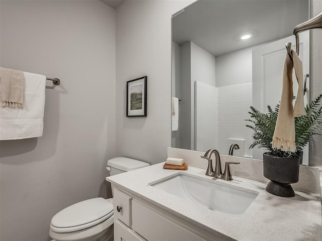 bathroom with vanity, toilet, and a shower