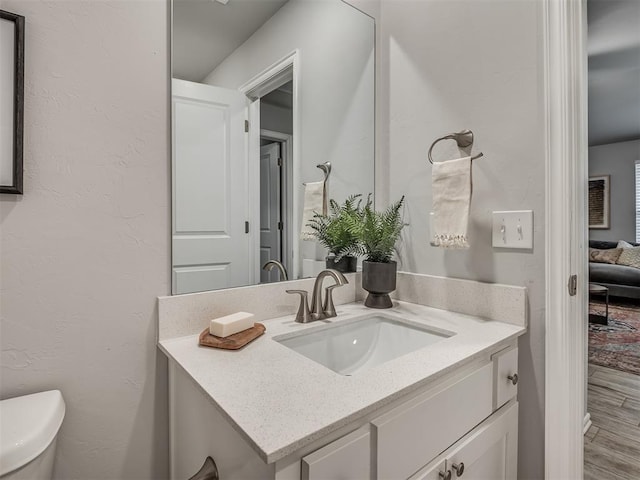 bathroom with vanity, hardwood / wood-style floors, and toilet