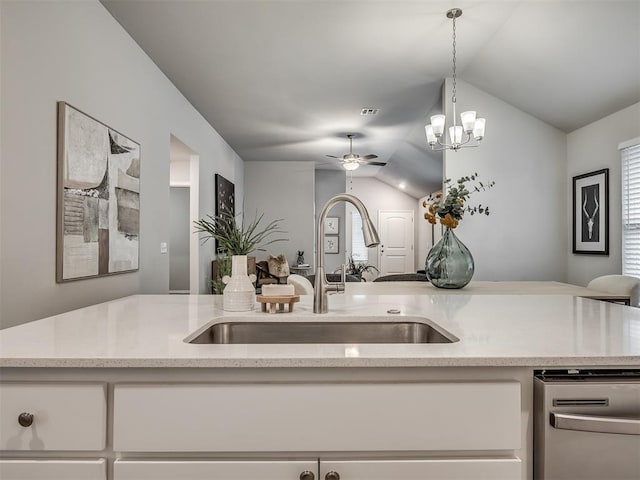 kitchen with lofted ceiling, sink, dishwasher, white cabinets, and decorative light fixtures