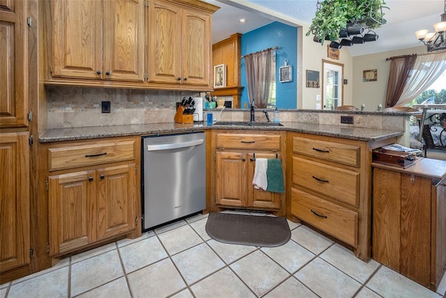 kitchen with light tile patterned flooring, tasteful backsplash, dishwasher, sink, and kitchen peninsula