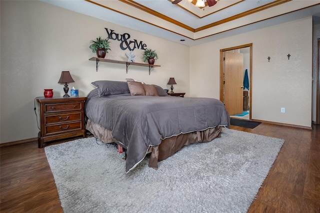 bedroom with dark hardwood / wood-style flooring and a raised ceiling