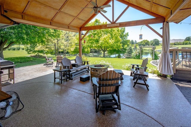 view of patio / terrace featuring a water view, ceiling fan, an outdoor fire pit, and a gazebo