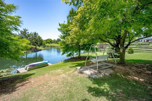 dock area with a water view and a yard