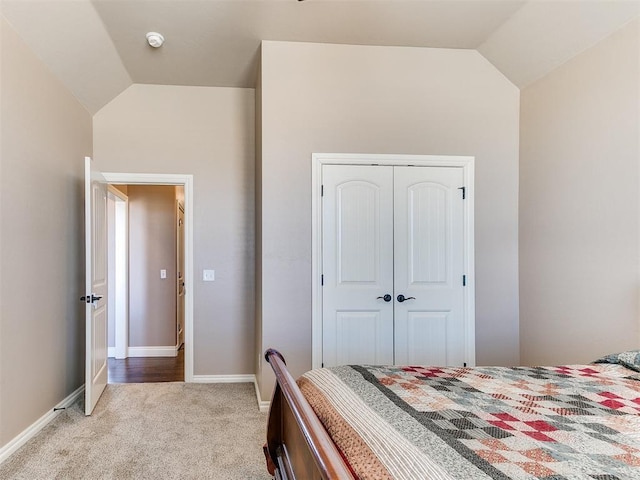 bedroom with light carpet, vaulted ceiling, and a closet