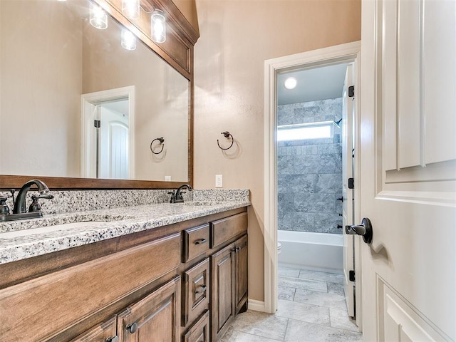 full bathroom featuring tiled shower / bath, vanity, and toilet