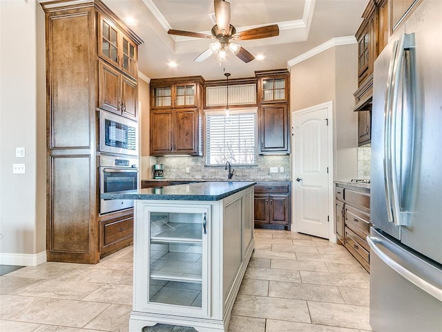 kitchen with tasteful backsplash, ornamental molding, a tray ceiling, stainless steel appliances, and beverage cooler