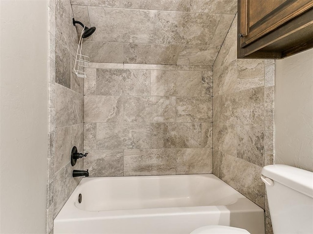 bathroom featuring tiled shower / bath combo and toilet