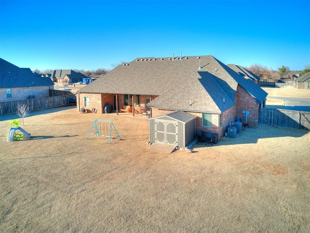 back of house with a shed and central AC