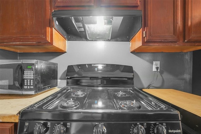 kitchen with ventilation hood and black appliances