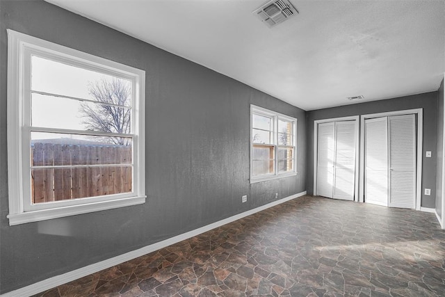 unfurnished bedroom featuring multiple closets