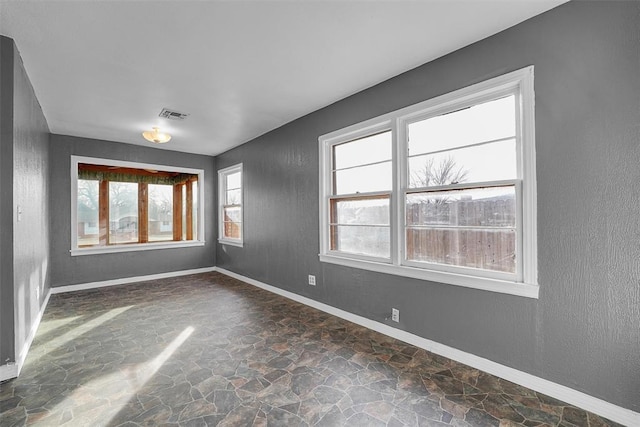 unfurnished room featuring plenty of natural light