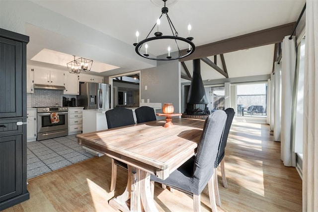 dining room with light wood-type flooring and an inviting chandelier