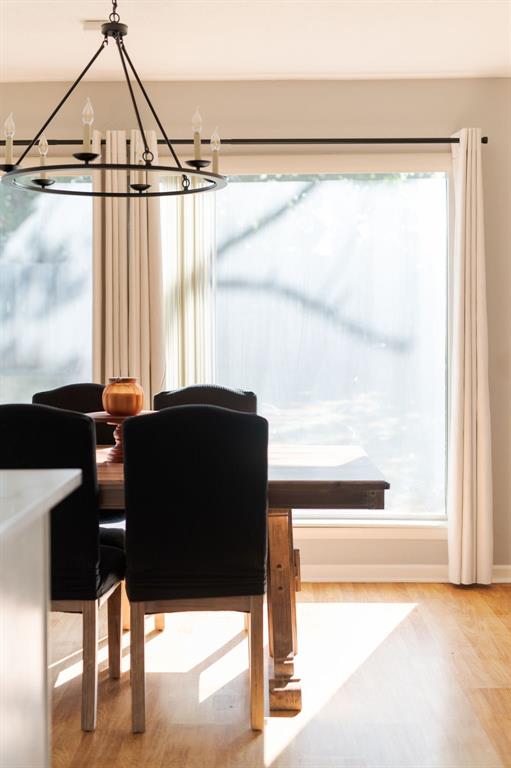 dining room with wood-type flooring and an inviting chandelier