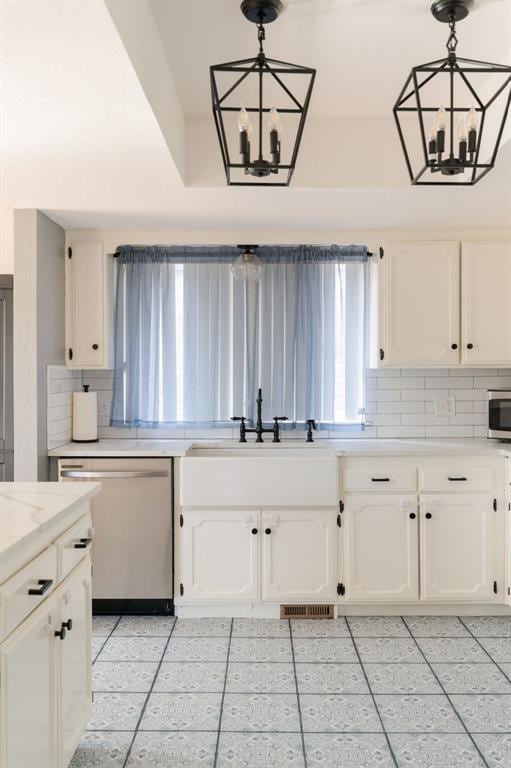 kitchen with an inviting chandelier, pendant lighting, stainless steel appliances, and white cabinetry