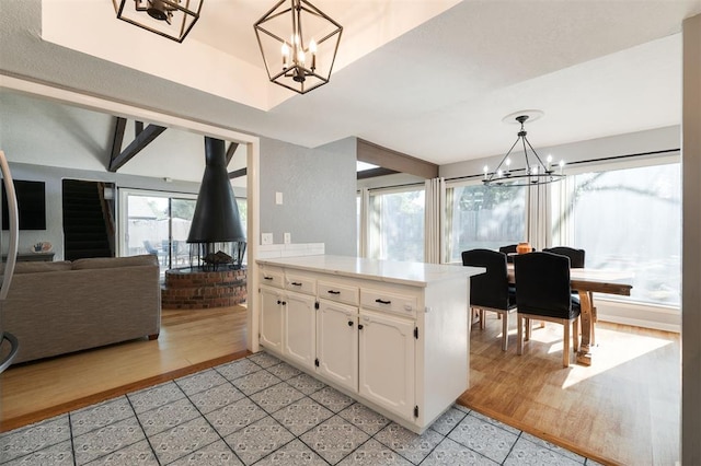 kitchen with white cabinets, decorative light fixtures, a chandelier, and light wood-type flooring