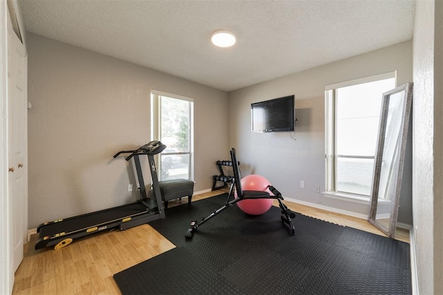 workout area with hardwood / wood-style flooring and a textured ceiling