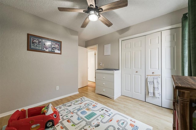 bedroom featuring a closet, ceiling fan, a textured ceiling, and light hardwood / wood-style flooring