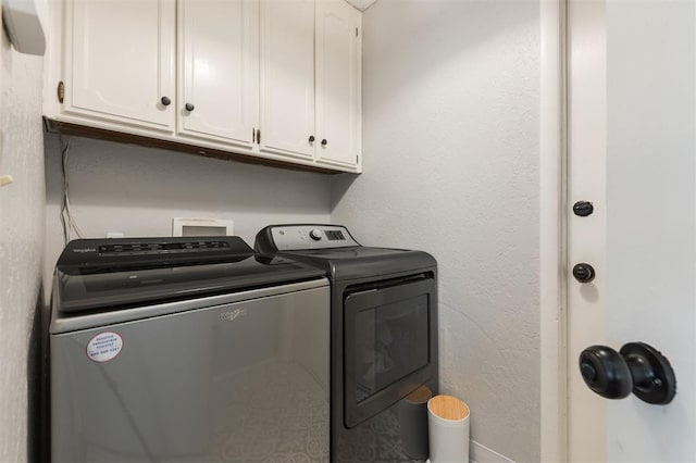 washroom with cabinets and washing machine and dryer