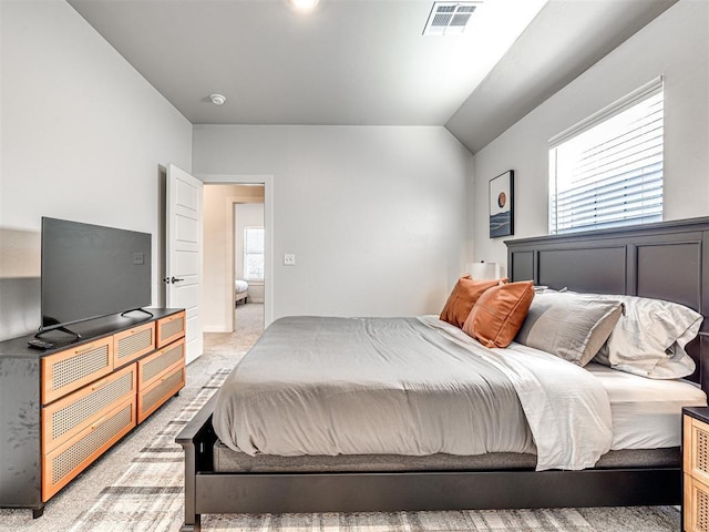 bedroom featuring lofted ceiling and light carpet