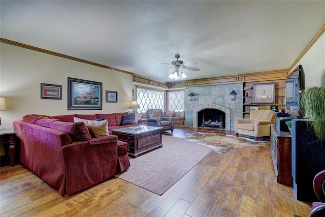 living room with ornamental molding, ceiling fan, and light wood-type flooring