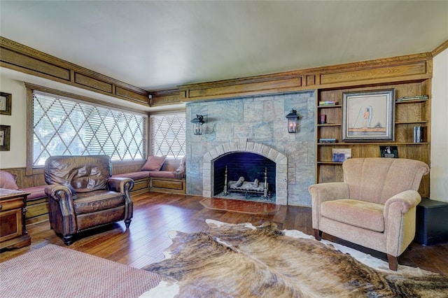 living room with a tiled fireplace and hardwood / wood-style flooring