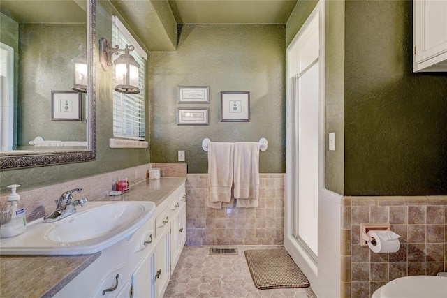 bathroom featuring tile walls, vanity, tile patterned flooring, and an enclosed shower