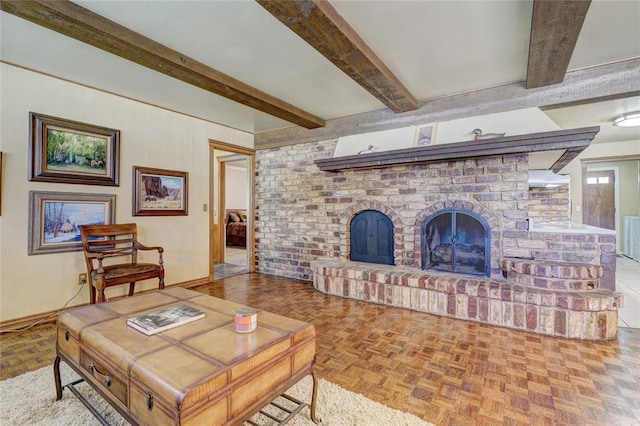 living room featuring parquet flooring, beam ceiling, and a fireplace