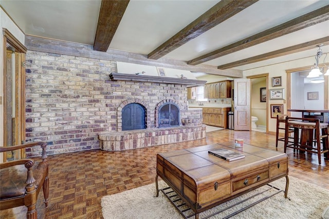 living room featuring parquet floors, a brick fireplace, and beamed ceiling