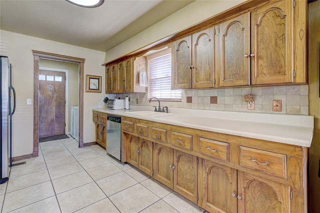 kitchen featuring tasteful backsplash, appliances with stainless steel finishes, light tile patterned flooring, and sink