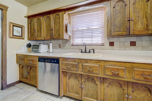 kitchen featuring sink, backsplash, light tile patterned floors, and dishwasher