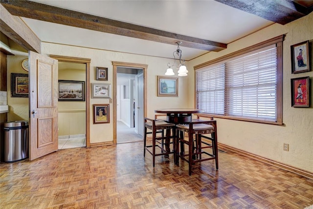 dining room with parquet floors, a notable chandelier, and beam ceiling