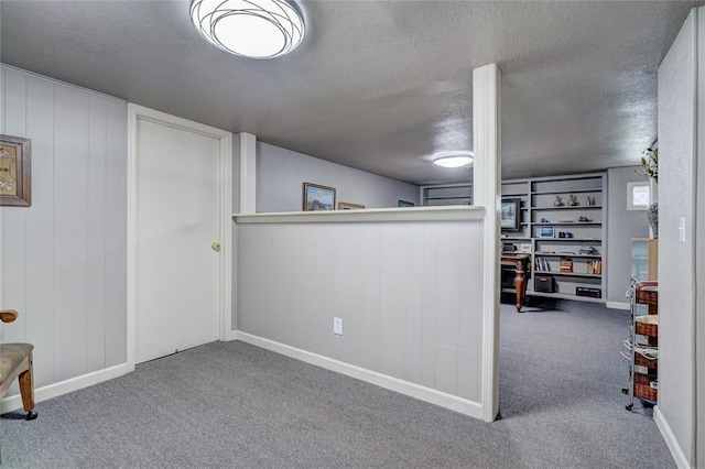 basement featuring a textured ceiling and carpet flooring