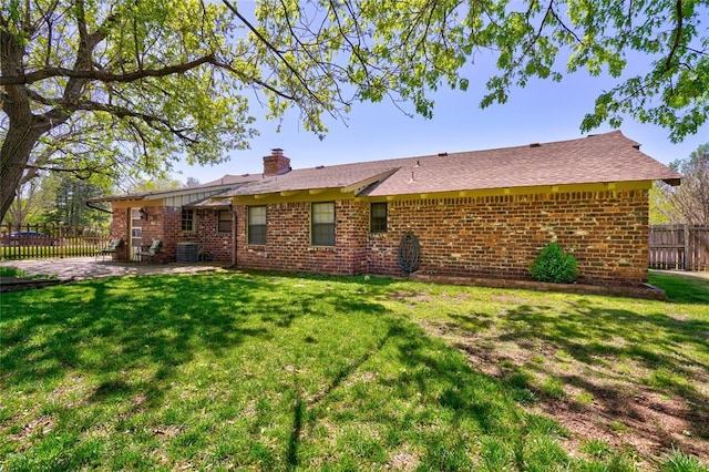 back of house featuring a lawn, central air condition unit, and a patio area