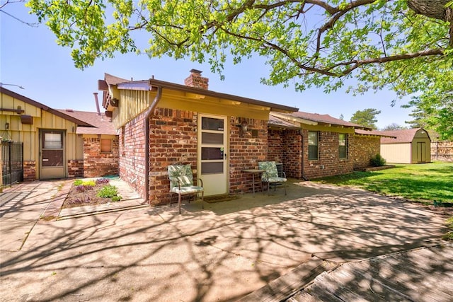 back of property with a yard, a patio, and a storage unit