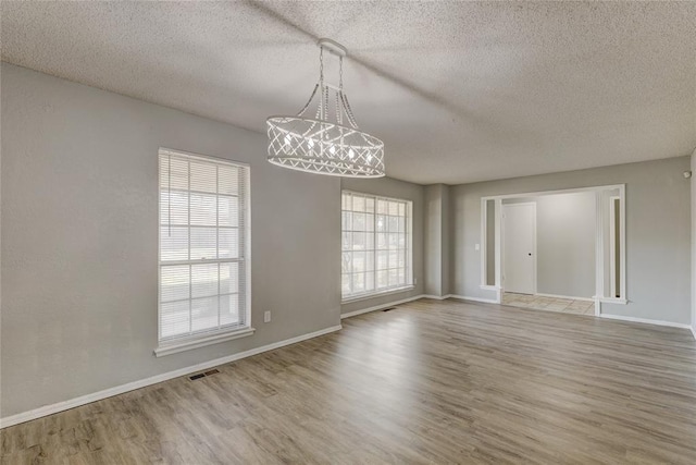 spare room featuring hardwood / wood-style floors and a textured ceiling