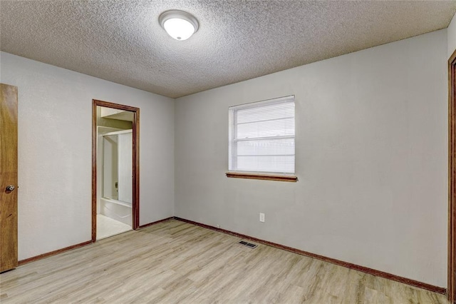 empty room featuring a textured ceiling and light wood-type flooring