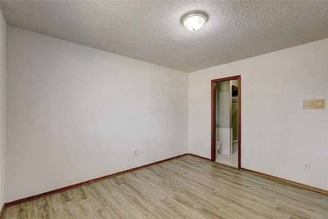 unfurnished room with light hardwood / wood-style floors and a textured ceiling