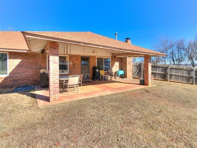 back of property featuring ceiling fan, a patio area, and a lawn