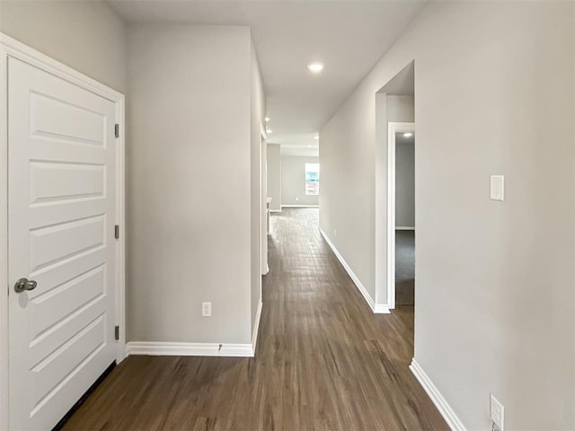 hallway featuring recessed lighting, baseboards, and dark wood-style floors