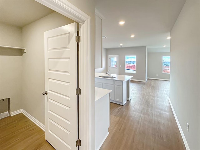 hallway featuring sink and light wood-type flooring