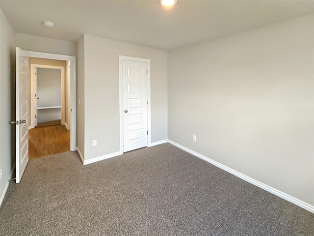 unfurnished bedroom with dark colored carpet