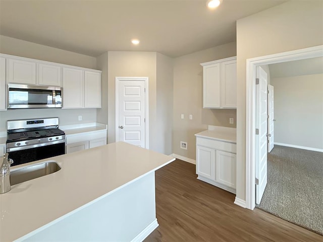 kitchen featuring white cabinetry, appliances with stainless steel finishes, dark wood-type flooring, and sink