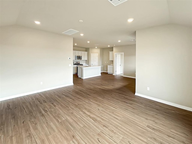 unfurnished living room with lofted ceiling and light hardwood / wood-style flooring