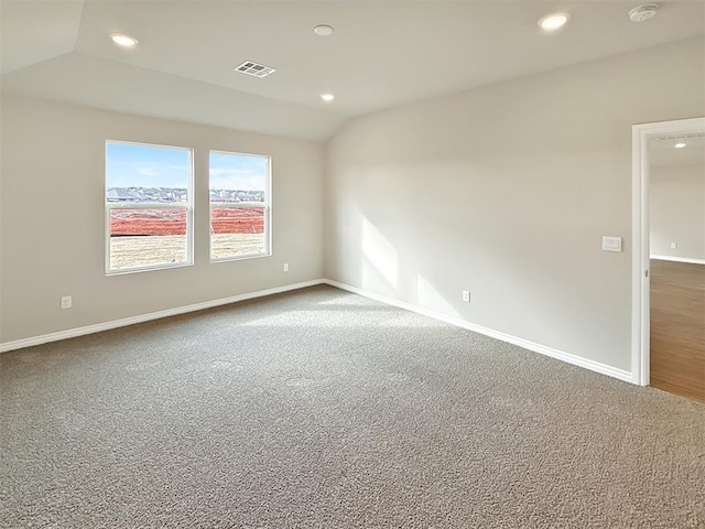 spare room featuring lofted ceiling and carpet flooring