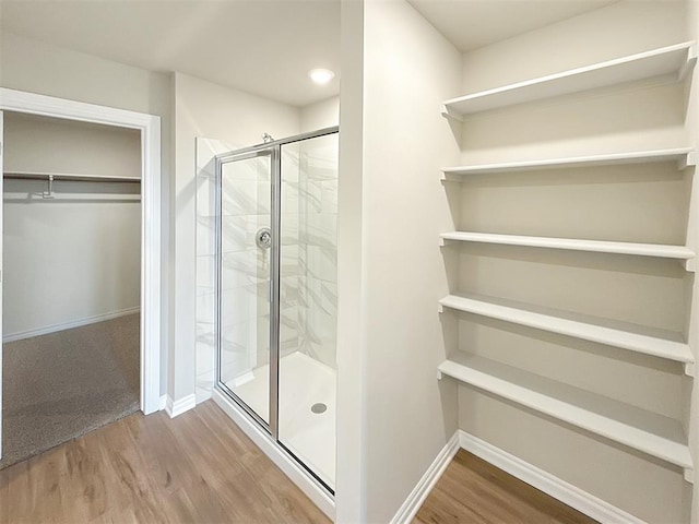 bathroom featuring walk in shower and hardwood / wood-style flooring