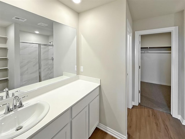 bathroom featuring walk in shower, vanity, and hardwood / wood-style floors