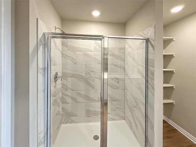 bathroom with wood-type flooring and an enclosed shower