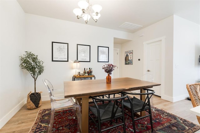 dining room featuring light hardwood / wood-style flooring and a chandelier